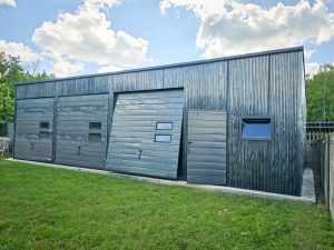 Fémgarázs / Acélcsarnok 12×7 m, matt grafit szín, garázsajtó automatizálással, modell: Kale